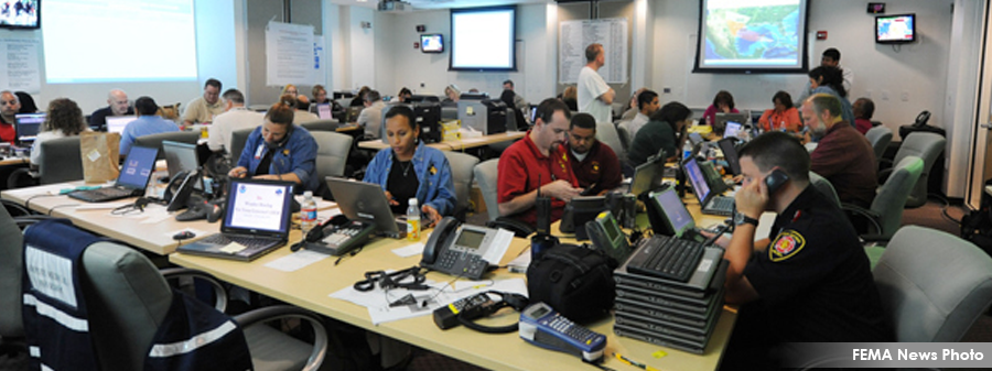 Google License Free - EOC in action - EOC personnel sitting at desks manning phones and computers.