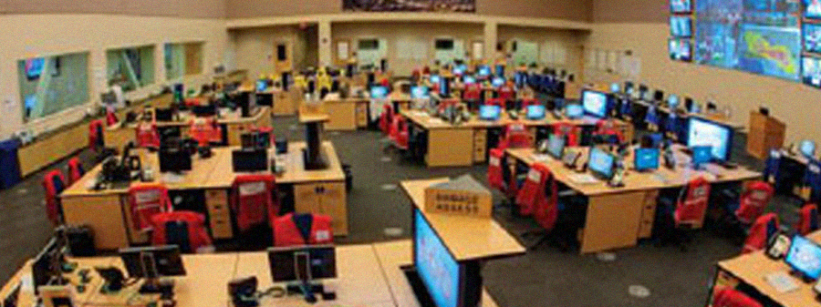 Empty EOC with large screens on the wall and computer screens on desks